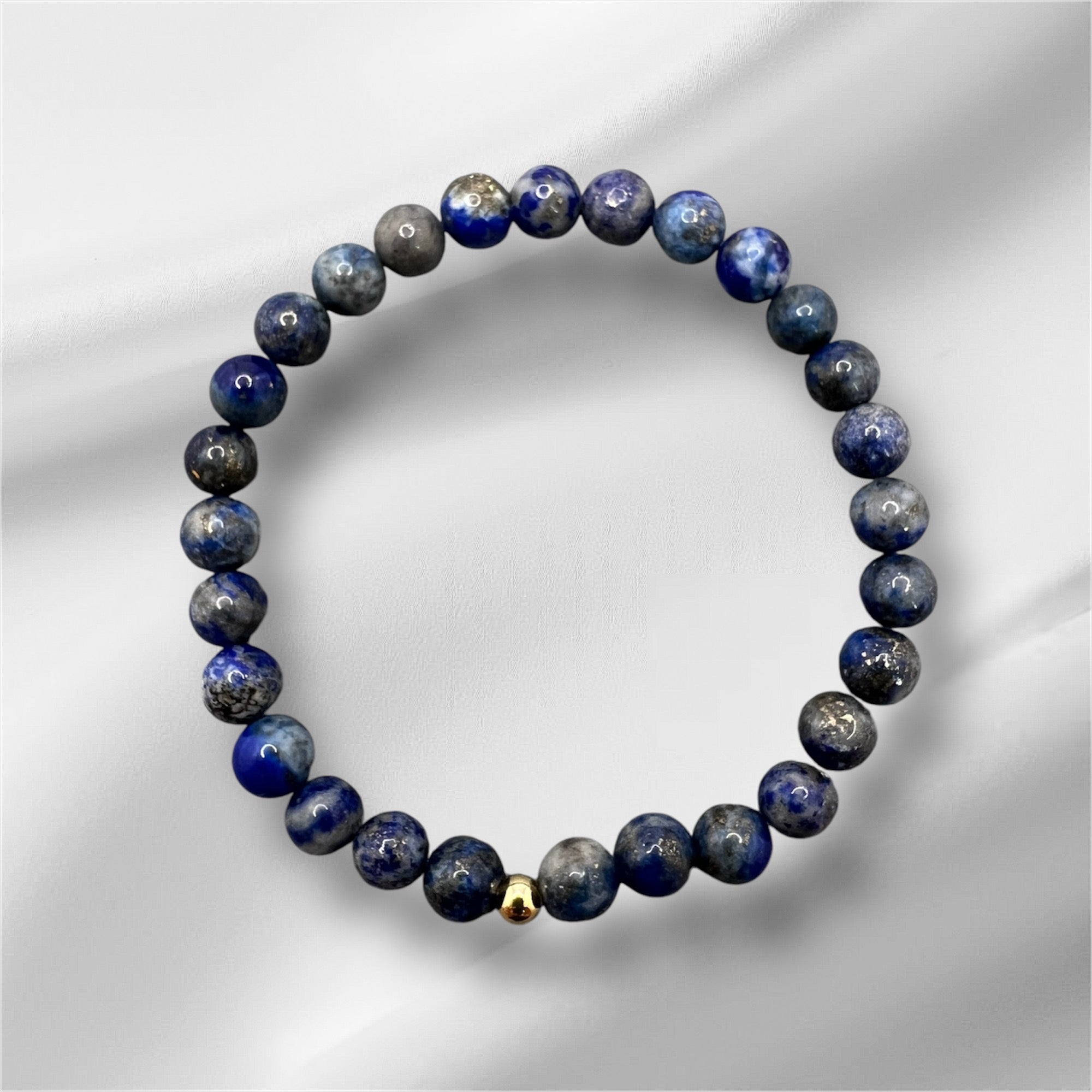 Handgefertigtes Lapislazuli Armband mit blauen Edelsteinperlen und goldener Verschlussperle, symbolisiert Weisheit und innere Wahrheit.