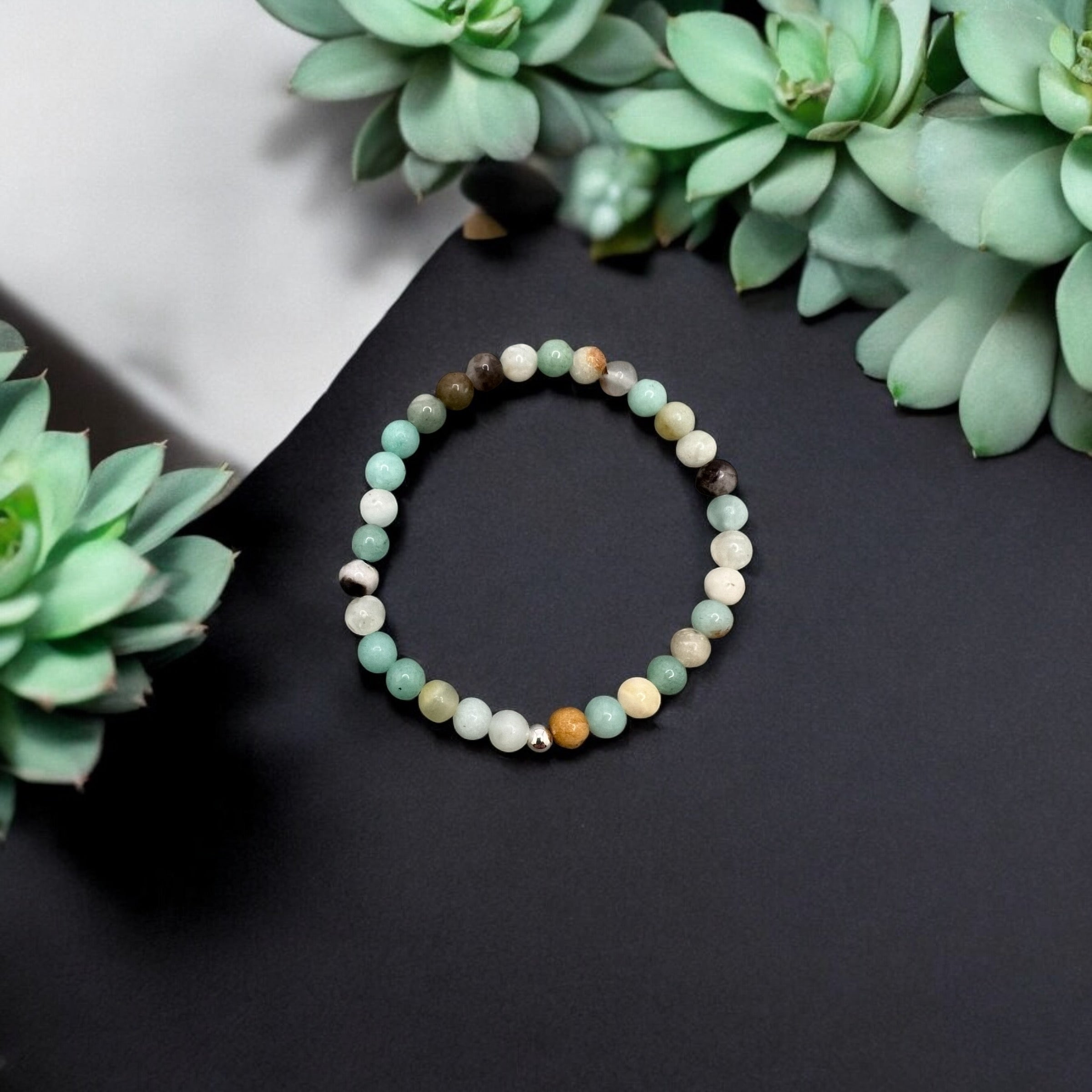 Amazonit Armband made of 6mm round mint green amazonite beads on black background with green succulents.