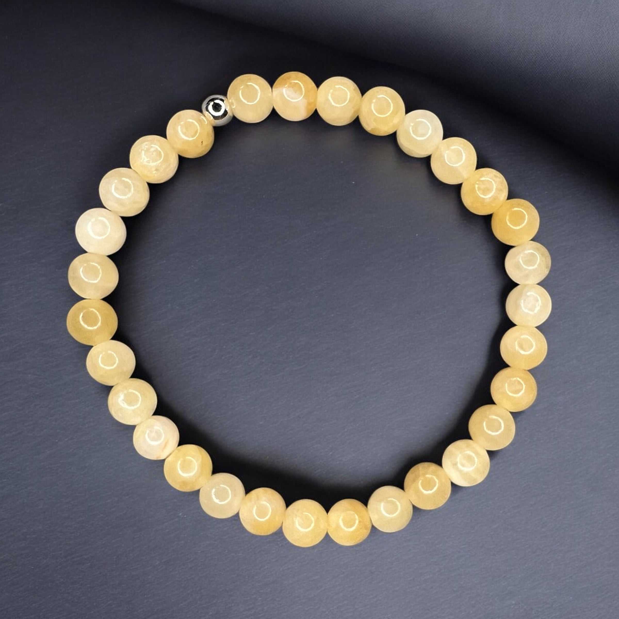 Handcrafted yellow chalcedony bracelet for optimism and inner calm, featuring elegant gemstone beads on a dark background.