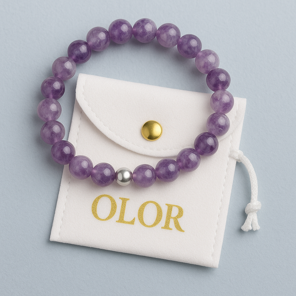 Amethyst Armband mit lila Edelsteinperlen und silberner Verschlussperle auf weißem Schmuckbeutel, handgefertigt für Schutz und innere Ruhe.