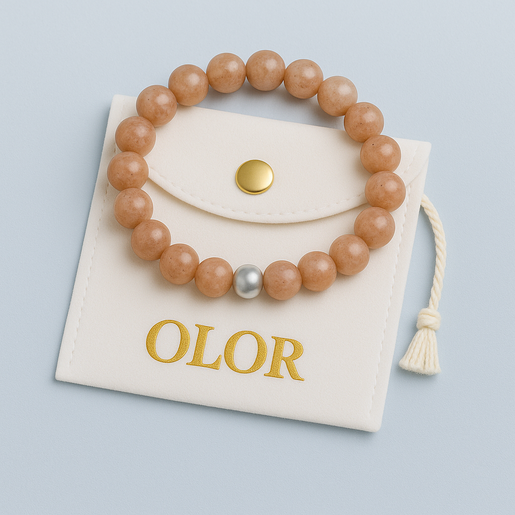 Handgefertigtes Sonnenstein Armband mit goldener Perle auf hellbeigem Schmuckbeutel, symbolisiert Lebensfreude und Positivität.