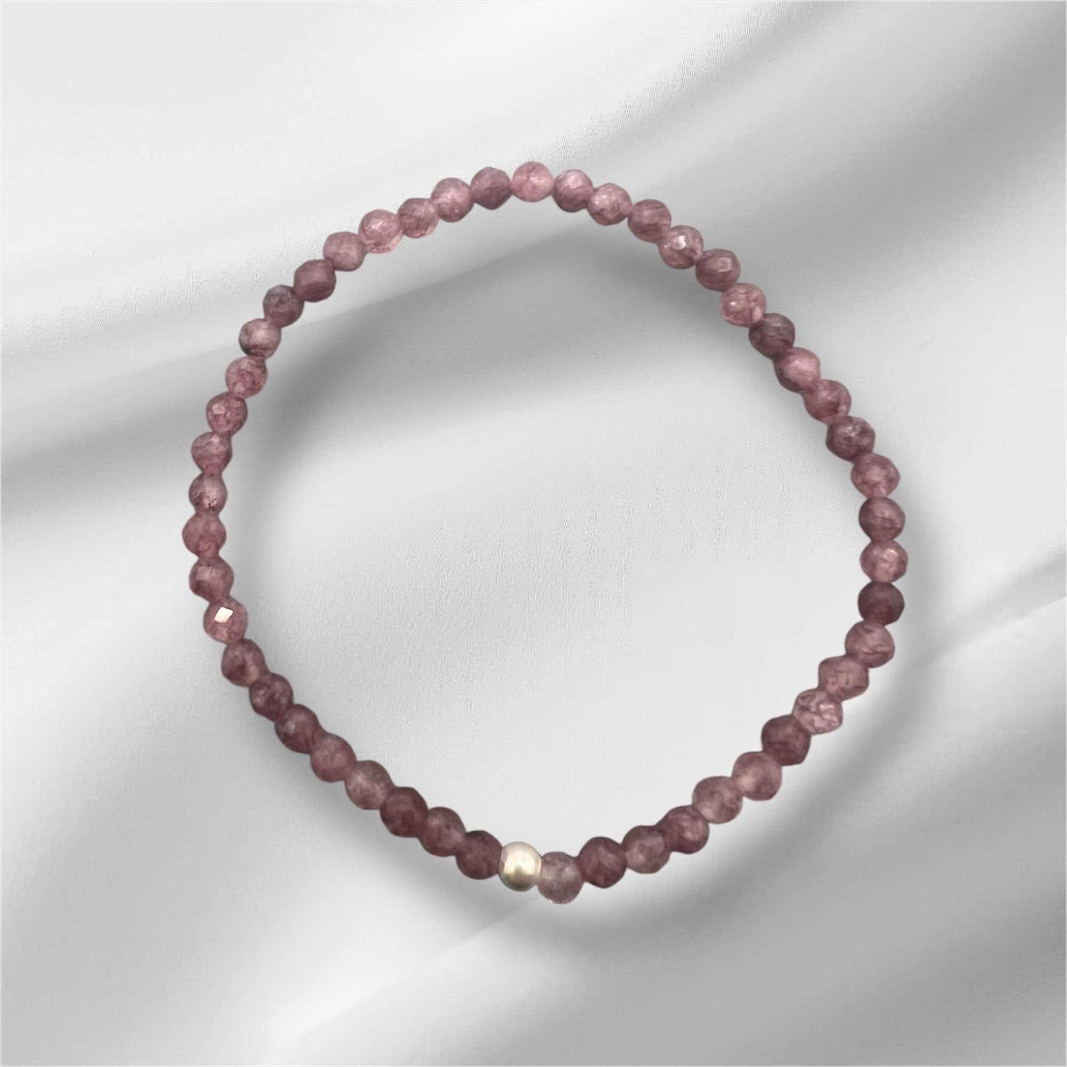 Lepidolith Edelstein Armband neben OLOR-Schmucktasche und Engel-Anhänger