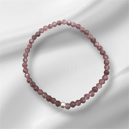 Nahaufnahme eines facettierten Lepidolith Armbands mit goldener Detailperle