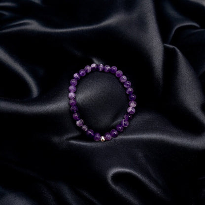 Handgefertigtes Amethyst Armband mit violetten Edelsteinperlen auf schwarzem Satin für Schutz und innere Ruhe