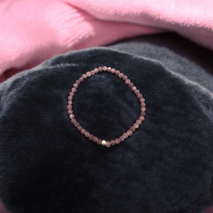 Faceted 4mm Lepidolith Armband with light violet beads symbolizing inner peace and protection, displayed on dark fabric background