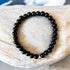 Onyx bracelet for inner strength and protection, hand-crafted black gemstone jewelry on display.