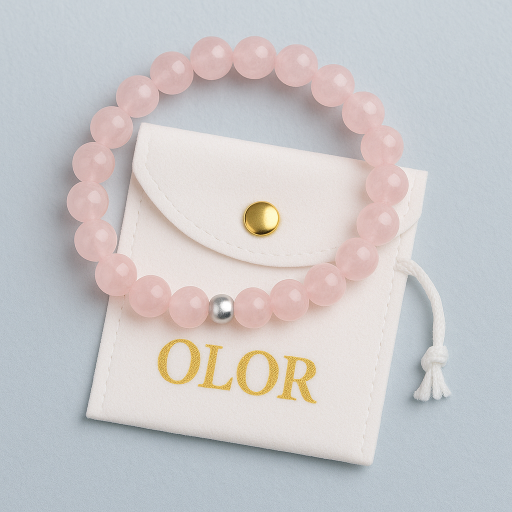 Rosenquarz Armband mit zarten rosa Perlen und Silberverschluss, handgefertigt für Liebe und Harmonie, präsentiert auf weißem Stoffbeutel.