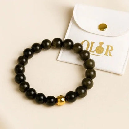 Handcrafted Gold Obsidian Armband with black and gold beads for protection and grounding, accompanied by a white OLOR pouch.